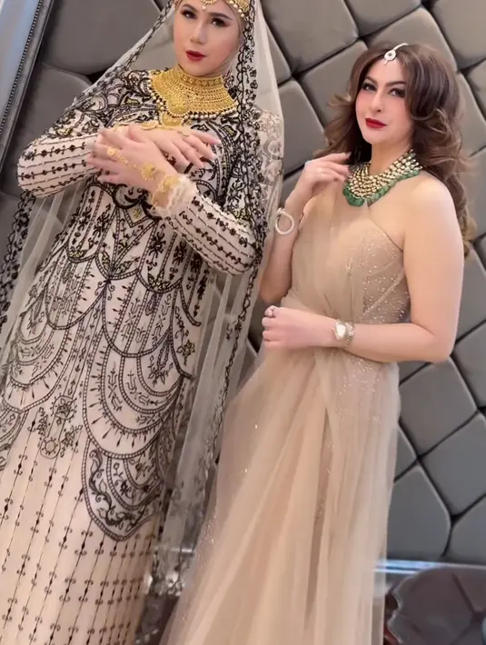 Marini Zumarnis tampil dengan selendang di kepala transparan berbordir hitam senada dengan long dressnya. Aksesori kepala, kalung layering, dan gelang emas membuat tampilannya khas India. Diana Pungky mengenakan dress heart neck nude beads putih dengan selendang tulle, dipadukan aksesori dan kalung layering emas hijau. [@marinizumarnisreal]