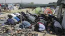 Para imigran terlihat khusyuk saat menggelar salat Jumat di sebuah kamp darurat perbatasan Yunani-Makedonia,desa Idomeni, Yunani (8/4). Meski tengah mencari perlindungan, mereka tak melalaikan kewajibannya sebagai seorang muslim. (REUTERS/Marko Djurica)