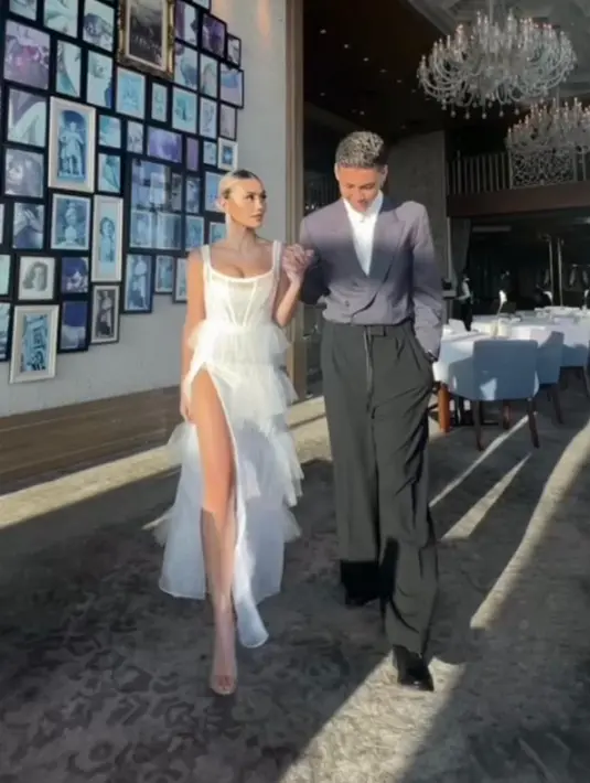 Di foto kedua, Agnez Mo mengenakan gaun putih dengan atasan bustier dan belahan rok yang cukup tinggi. Aksen fringe berlayer di bagian rok beri kesan feminin yang elegan.  [@agnezmo]