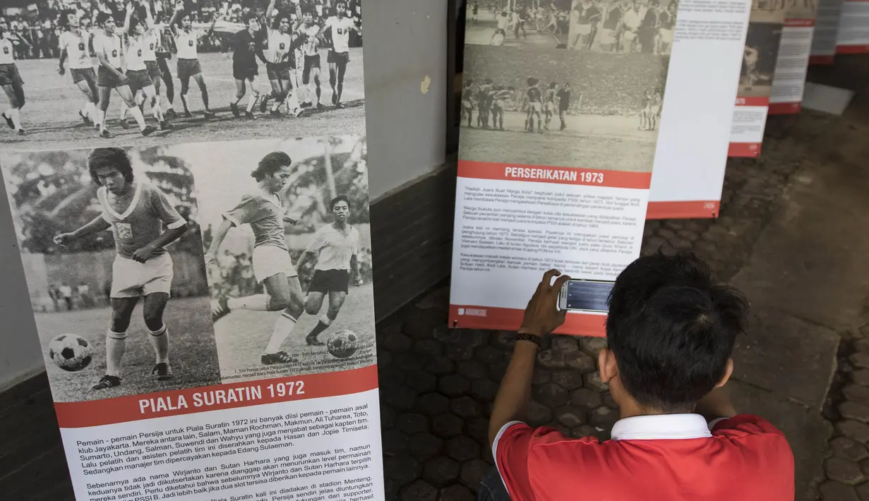 Pengunjung memperhatikan cerita-cerita saat pameran foto memperingati hari jadi Persija Jakarta di Lapangan Banteng, Jakarta, Jumat (28/11/2015). (Bola.com/Vitalis Yogi Trisna)