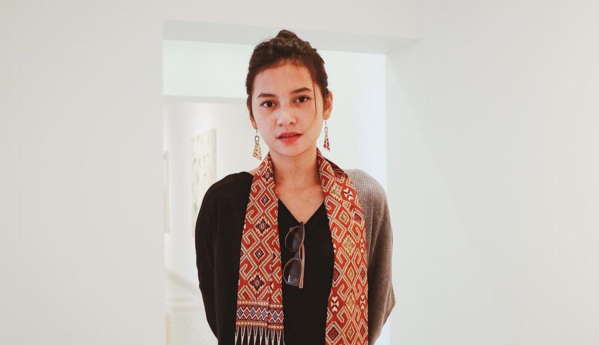 Dengan kain khas nusantara, Indah tampil simpel dengan baju hitam. Kacamata hitam digantungkan di kerah bajunya dan anting emas melengkapi penampilan casualnya. Indah memang kerap berpenampilan sederhana dengan kombinasi kain khas nusantara. (Liputan6.com/IG/indahpermatas)