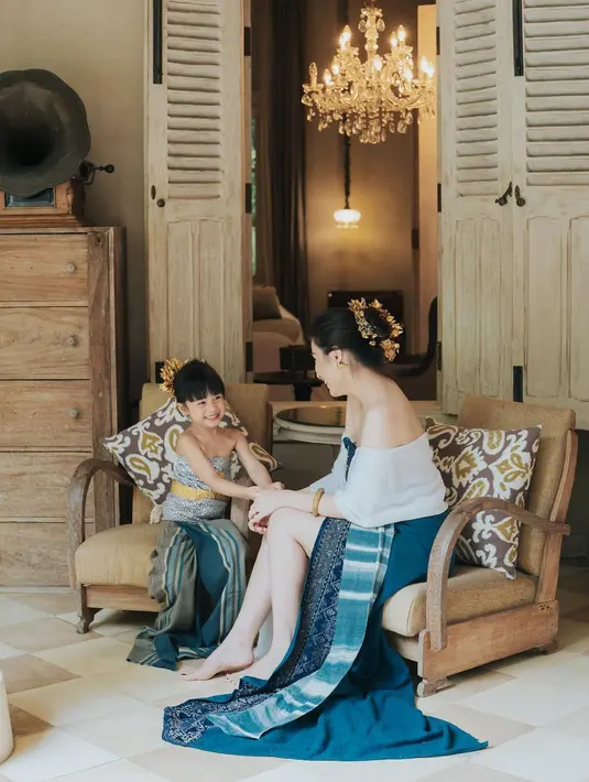 Kali ini tampil menggemaskan dengan balutan kain bali bernuansa biru, Natusha berpose kompak dengan sang ibu. Ia bahkan menambahkan detail aksesori di rambut dan kain yang diikat di bagian pinggang. Foto: Instagram.