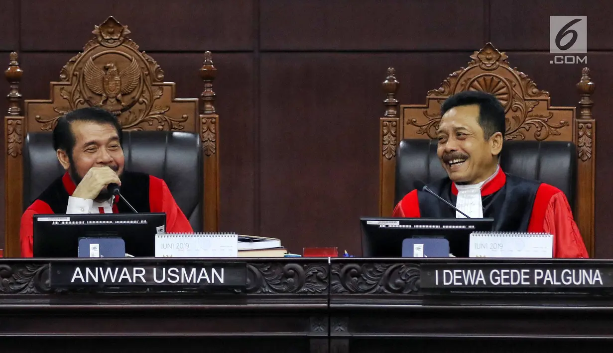 Hakim Konstitusi Anwar Usman dan I Dewa Gede Palguna tertawa saat sidang ke-5 sengketa Pilpres 2019 di Gedung MK, Jakarta, Jumat (21/6/2019). Sidang beragendakan mendengar keterangan saksi dan ahli dari pihak terkait yakni paslon nomor urut 01 Jokowi-Ma'ruf Amin. (Liputan6.com/Johan Tallo)