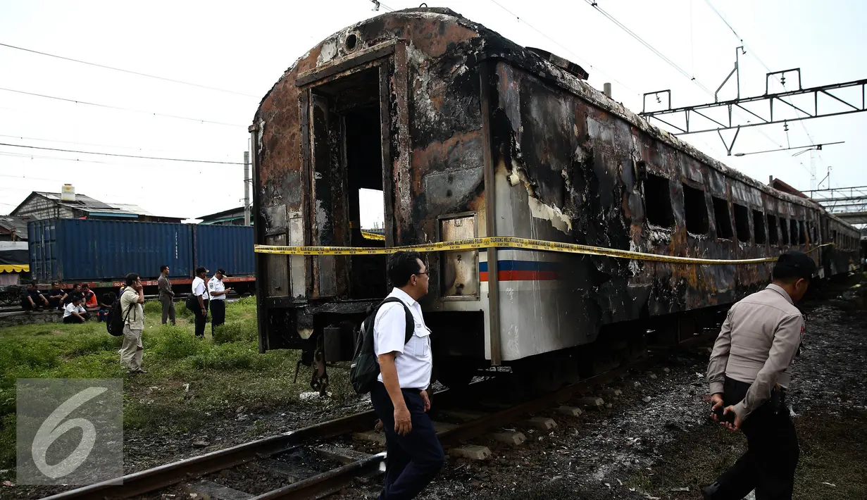 Petugas melihat kondisi dua gerbong Kereta Kertajaya jurusan Surabaya-Jakarta usai terbakar di Stasiun Tanjung Priok, Jakarta, Kamis (25/8). (Liputan6.com/Faizal Fanani)