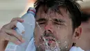 Petenis Swiss, Stan Wawrinka menaruh handuk es di lehernya dan menyiramkan air ke wajahnya karena kepanasan saat istirahat bertanding melawan Ugo Humbert asal Prancis di putaran kedua AS Terbuka, New York, Rabu (29/8). (AP Photo/Seth Wenig)