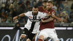 Gelandang AS Roma, Daniele De Rossi, berebut bola dengan striker Parma, Fabio Ceravolo, pada laga Serie A di Stadion Olympic, Roma, Minggu (26/5). Laga ini perpisahan bagi De Rossi dan AS Roma setelah 18 tahun. (AFP/Filippo Monteforte)