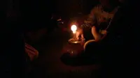 Foto: Beberapa anak-anak sekolah belajar malam menggunakan lampu pelita (Liputan6.com/Dion)
