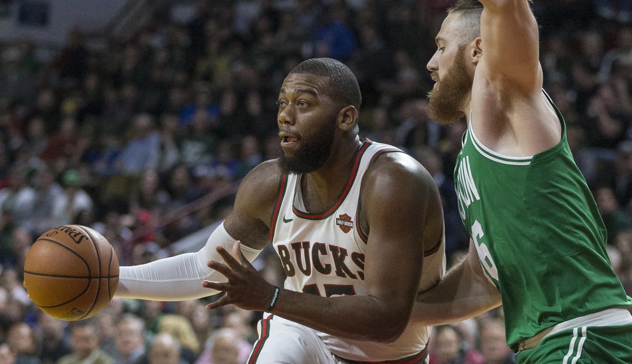 Pemain Milwaukee Bucks, Greg Monroe (kiri) menggiring bola melewati adangan pemain Boston Celtics, Aron Baynes pada laga NBA di basketball game di Milwaukee, (26/10/2017). Boston menang 96-89. (AP/Tom Lynn)
