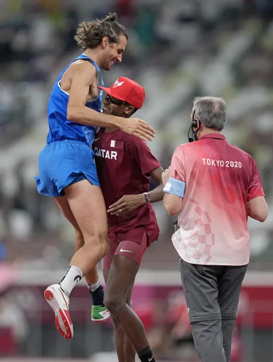 Gianmarco Tamberi (kiri) dari Italia merayakan dengan Mutaz Barshim dari Qatar setelah mereka memenangkan emas bersama di final lompat tinggi putra Olimpiade Tokyo 2020 di Tokyo, Jepang, Minggu (1/8/2021). Kedua atlet berpelukan saat panitia menyetujui pembagian emas. (AP Photo/Martin Meissner)
