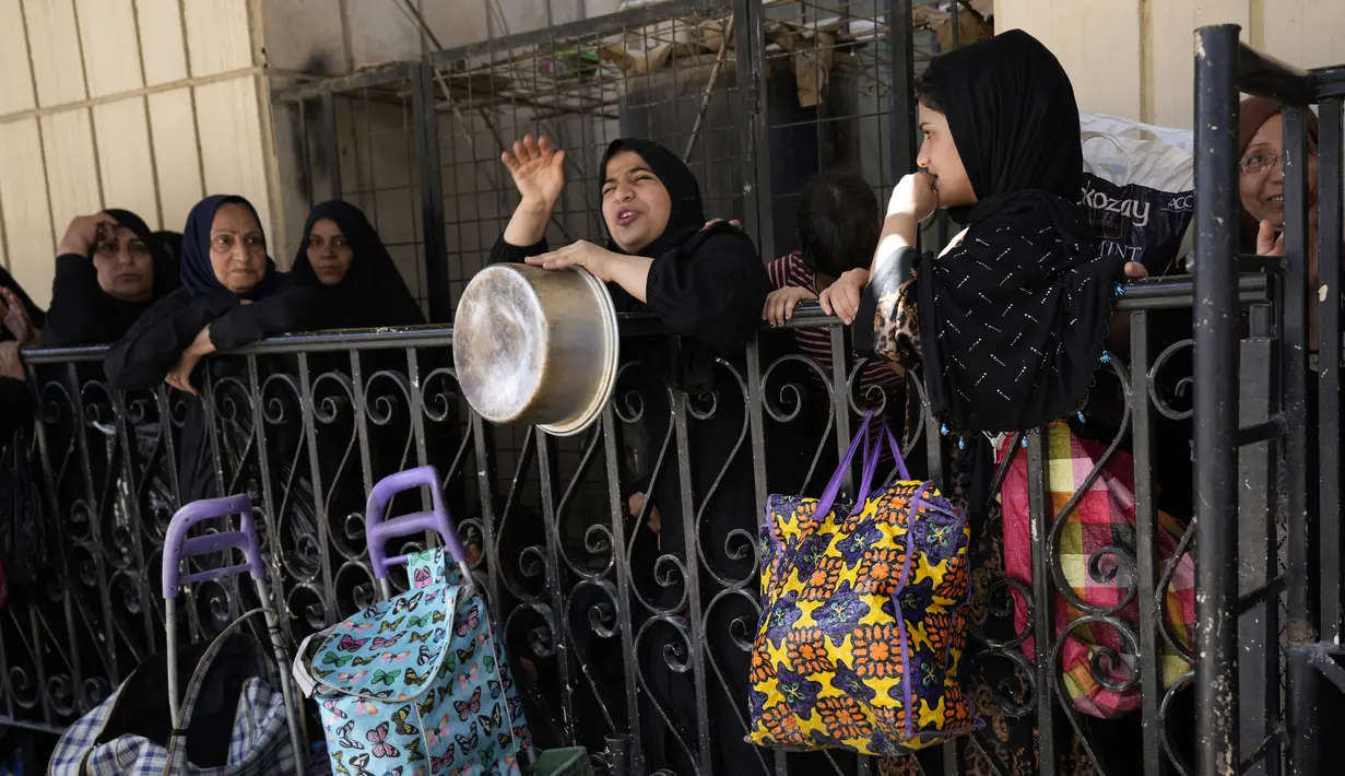 <p>Warga berdatangan dengan membawa wadah masing-masing. Mereka pun membuat antrean untuk menerima makanan dari pihak masjid. (AP Photo/Hadi Mizban)</p>