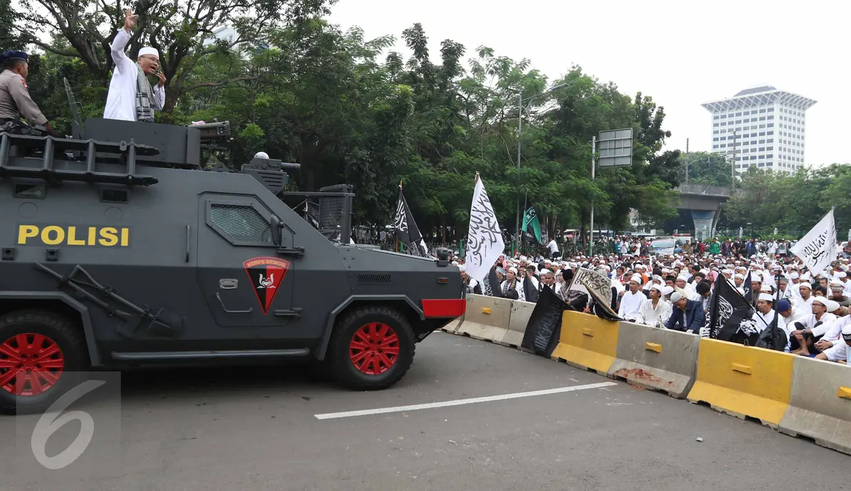 Penceramah menyampaikan khotbah di atas mobil barakuda di Jalan Merdeka Barat, Jakarta, Jumat (4/11). Massa aksi damai 4 November terlihat mendengarkan khotbah salat Jumat yang digelar di atas aspal. (Liputan6.com/Faizal Fanani)