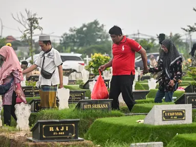 Umat Muslim mengunjungi makam kerabat mereka di sebuah pemakaman sebelum dimulainya bulan Ramadan, di Surabaya pada 27 Februari 2025. (JUNI KRISWANTO/AFP)