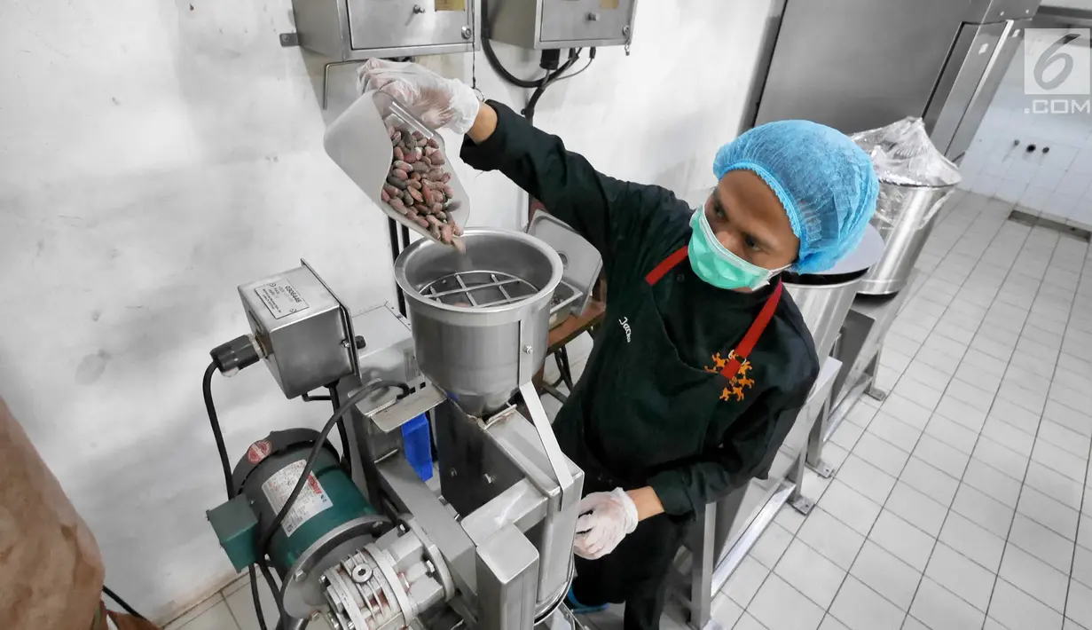 Pekerja memasukkan biji kakao ke dalam mesin giling di toko Pipiltin Cocoa kawasan Barito, Jakarta, Kamis (13/9). Para atlet Asian Games 2018 banyak memburu Pipiltin Cocoa sebagai oleh-oleh. (Liputan6.com/Herman Zakharia)