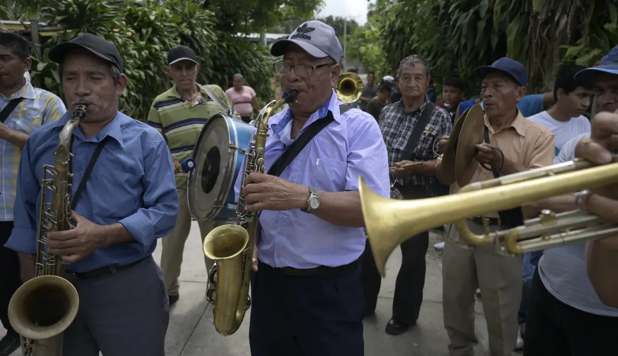 Pria memainkan musik selama perayaan Santa Cruz di Santa Maria Ostuma, 65 km timur San Salvador (31/5/2022). Ratusan orang Salvador membawa buah dengan yodes kayu berjalan melalui desa Santa Maria Ostuma di El Salvador tengah untuk berterima kasih kepada Salib Suci atas panen yang melimpah. (AFP/MARVIN RECINOS)