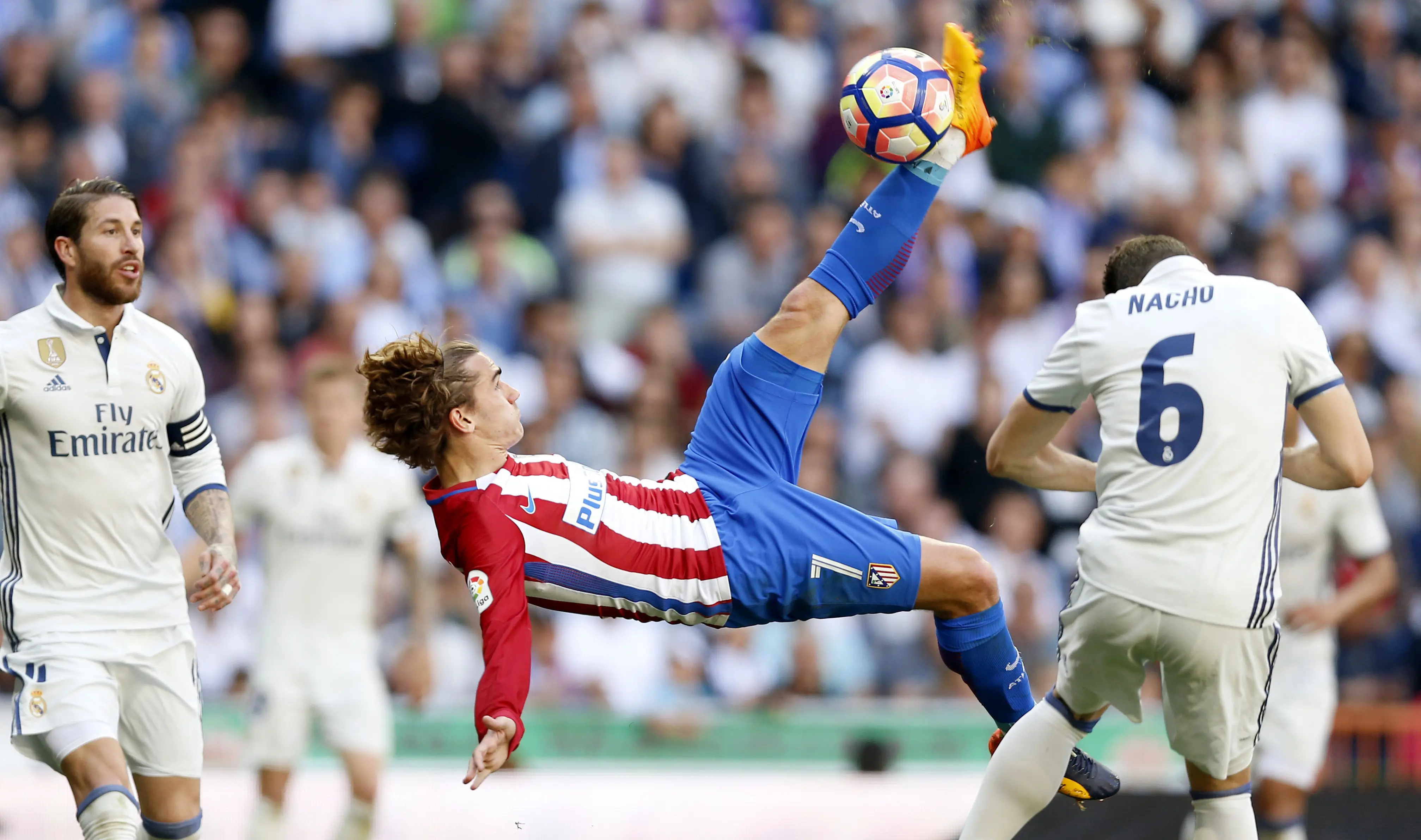 Pemain Atletico Madrid, Antoine Griezmann (tengah) melakukan tendangan salto ke gawang Real Madrid pada laga La Liga di Santiago Bernabeu stadium, Madrid, (8/4/2017). Real Madrid bermain Imbang 1-1 dengan Atletico.(AP/Daniel Ochoa de Olza)