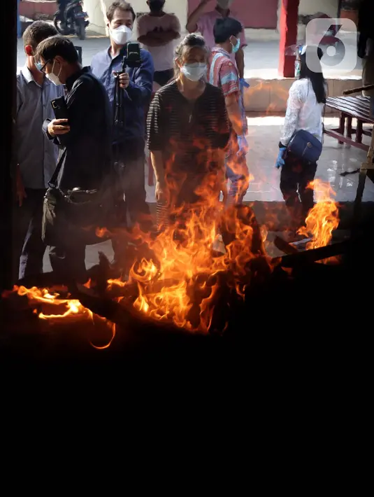 Keluarga dan kerabat menyaksikan proses kremasi jenazah di Krematorium Cilincing, Jakarta, Kamis (29/7/2021). Proses kremasi jenazah di Krematorium Cilincing masih menggunakan cara tradisional menggunakan kayu bakar dan membutuhkan waktu sekitar dua jam. (Liputan6.com/Helmi Fithriansyah)