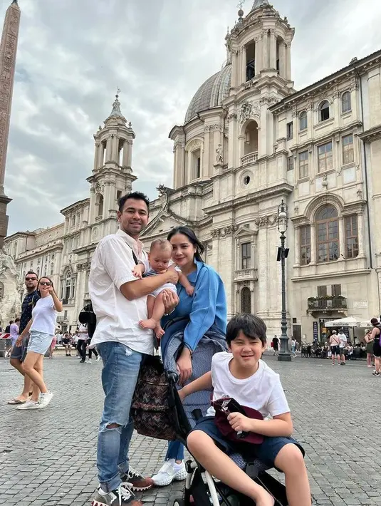 Raffi Ahmad tampil senada dengan putra sulungnya, Rafathar mengenakan baju warna putih dan celana jeans. Kemudian putra kedua mereka,  Rayyanza mengenakan overall warna putih. (Instagram/raffinagita1717).