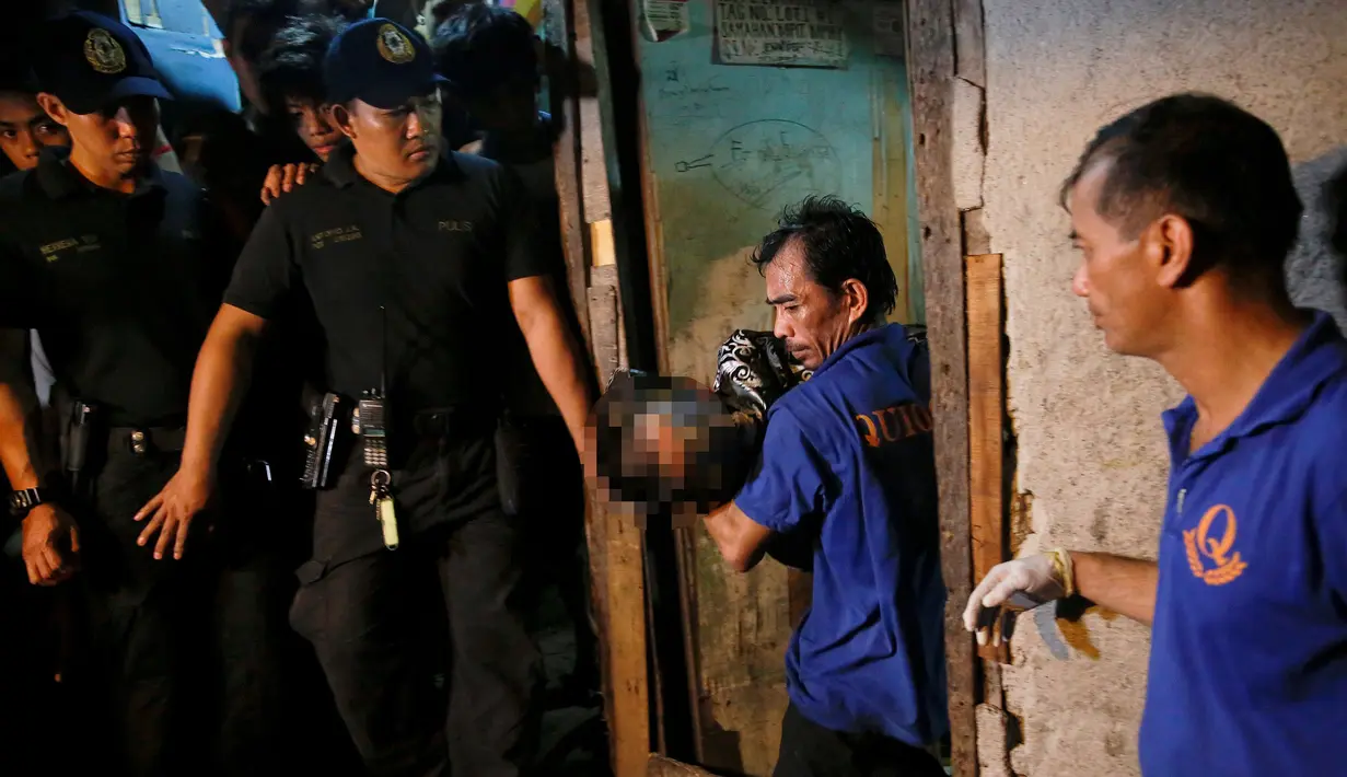 Petugas membawa tubuh korban yang tewas ditembak oleh orang tak dikenal dari dalam rumah di Manila, Filipina (1/11). Lima orang tersebut tewas di dalam rumah yang dikenal sebagai sarang obat-obatan terlarang. (REUTERS/Damir Sagolj
