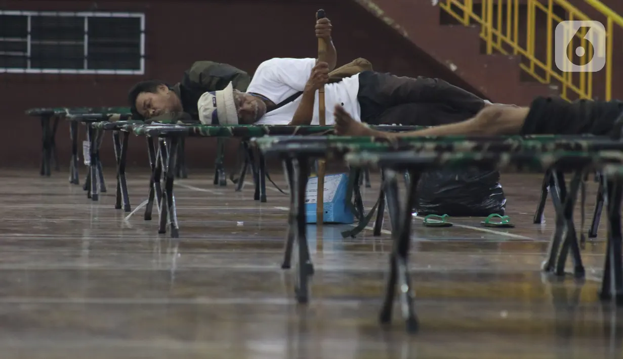 Para tunawisma beristirahat di GOR Ciracas, Jakarta, Selasa (28/4/2020). Untuk mencegah meluasnya virus Covid-19, Pemprov DKI Jakarta menyiapkan seluruh GOR di Jakarta untuk menampung tunawisma, salah satunya GOR Ciracas dengan kapasitas 100 tempat tidur. (Liputan6.com/Helmi Fithriansyah)