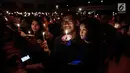 Jemaat menyalakan lilin dalam acara Natal Taruna Merah Putih di Jakarta, Jumat (22/12). Perayaan natal tersebut sebagai bentuk kepedulian terhadap kedaulatan Palestina. (Liputan6.com/Faizal Fanani)