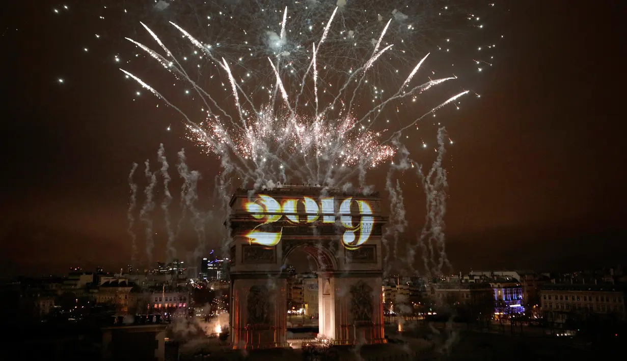 Kembang api menghiasi Arc de Triomphe saat perayaan malam Tahun Baru 2019 di Champs Elysees, Paris, Prancis, Selasa (1/1). (AP Photo/Kamil Zihnioglu)