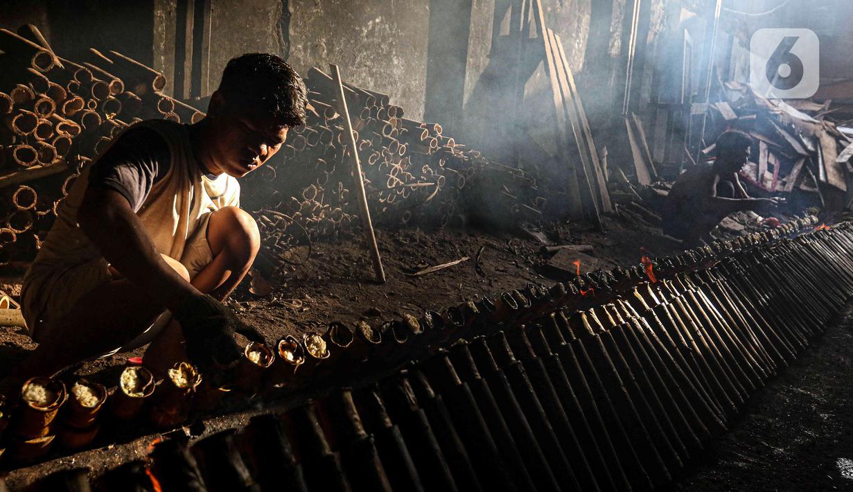 Pekerja melakukan pembakaran lemang bambu di Jalan Kramat Raya, Senen, Jakarta Pusat, Rabu (6/4/2022). Selama Ramadhan, pembuat lemang mampu memproduksi hingga 300 buah dalam sehari, meningkat hingga tiga kali lipat dari hari biasa. (Liputan6.com/Herman Zakharia)