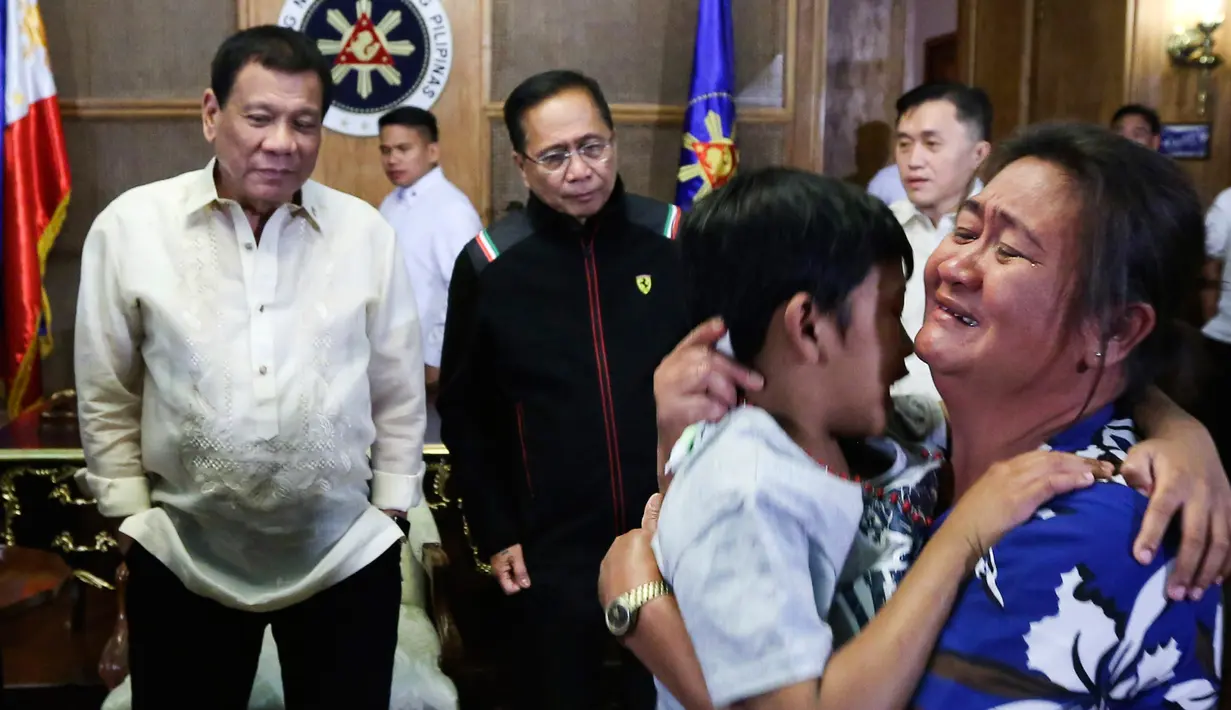 Seorang anak memeluk ibunya di Istana Malacanang, Manila, Filipina, Selasa (28/2). Presiden Filipina Rodrigo Duterte berhasil mempersatukan kembali orangtua dan anaknya usai diculik oleh kelompok Abu Sayyaf. (AP Photo)