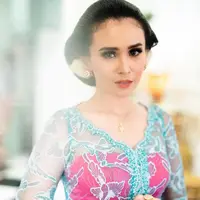 Ayushita tampil dengan sanggul klasik dihiasi bunga mawar saat prosesi langkahan menjelang pernikahan sang adik. Dipadukan kebaya biru dengan bustier fuschia. [@ayushita]