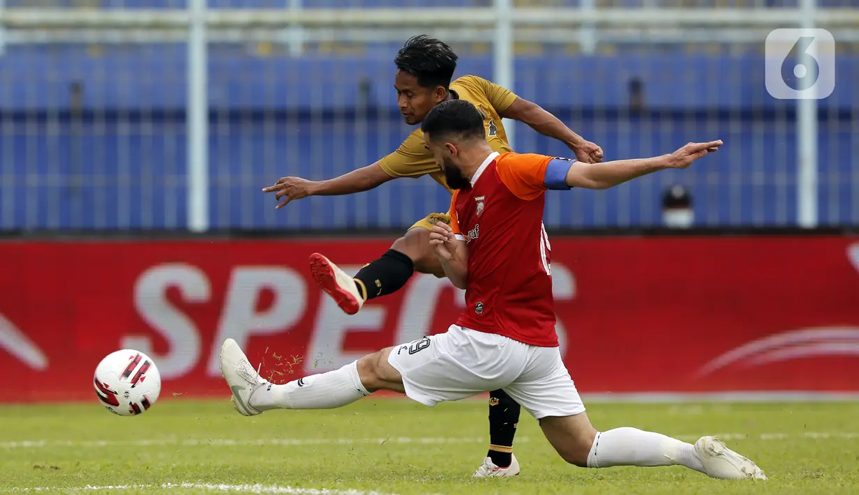 Pemain Borneo FC Samarinda Javlon Guseynov berusaha menghalau bola tembakan pemain Bhayangkara Solo FC Andik Vermansah dalam pertandingan babak penyisihan Piala Menpora 2021 di Stadion Kanjuruhan, Malang, Jawa Timur, Senin (22/3/2021). (Bola.com/Arief Bagus)