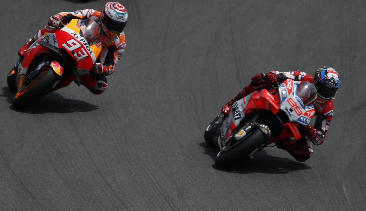 Pebalap Ducati, Jorge Lorenzo dibuntuti Pebalap Honda, Marc Marquez, pada balapan MotoGP 2018 di Sirkuit Catalunya, Spanyol, Minggu (17/6/2018). Lorenzo menjadi yang tercepat dengan catatan waktu 40 menit 13,566 detik. (AP/Eric Alonso)
