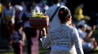 Seorang perempuan umat Hindu membawa sesajen untuk perayaan hari raya Galungan di Pura Jagat Natha di Denpasar, Bali, Rabu (8/6/2022). Di tahun 2022 ini, Hari Raya Galungan jatuh pada tanggal 8 Juni dan diikuti Hari Raya Kuningan pada tanggal 18 Juni. (SONNY TUMBELAKA / AFP)