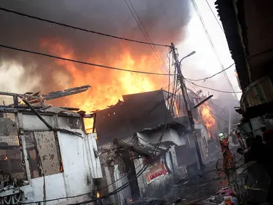 Warga berusaha memadamkan api pada kebakaran di Kompleks Bearland, Kelurahan Kebon Manggis, Matraman, Jakarta, (14/10/14). (Liputan6.com/Faizal Fanani)