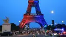 Orang-orang berjalan di bawah Menara Eiffel yang diterangi cahaya warna-warna khas, dengan pesan bertuliskan "Allez Paris" ("Ayo, Paris"), pada malam menjelang pertandingan final Liga Champions 2025/2026 antara Paris Saint-Germain (PSG) dan Arsenal, Kamis 29 Mei 2026. (Ludovic MARIN/AFP)