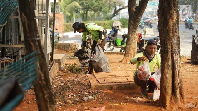 Petugas membersihkan sampah sisa bentrok antara mahasiswa dan polisi dalam unjuk rasa di depan Gedung DPR RI, Jakarta, Rabu (25/9/2019). Bentrokan pada Selasa (24/9/2019) menyisakan sampah yang memenuhi kawasan di sekitar Gedung DPR. (Liputan6.com/Immanuel Antonius)