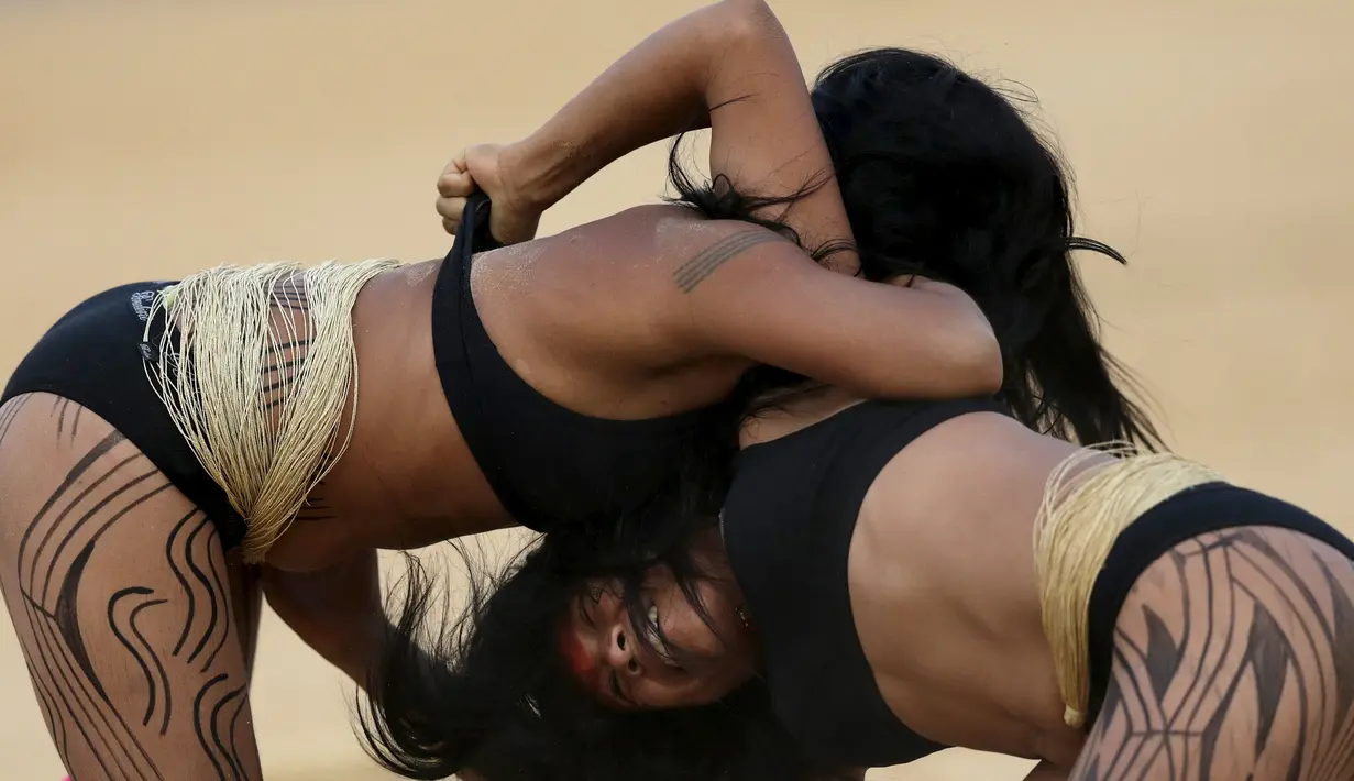 Dua wanita adat sedang bergulat dalam pertandingan yang disebut Huka Huka pada Olimpiade bagi Masyarakat adat, Palmas, Brasil, (30/10/2015). Sekitar 48 etnik yang akan terdiri atas empat ribu atlet ikut dalam Olimpiade ini. (REUTERS/Ueslei Marcelino)