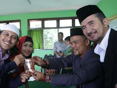 Suami Ria Irawan, Mayky Wongkar menerima buku nikah seusai Ijab Qabul di KUA Cilandak, Jakarta, Jumat (23/12). Aktris senior, Ria Irawan menikah untuk kedua kalinya. (Liputan6.com/Herman Zakharia)