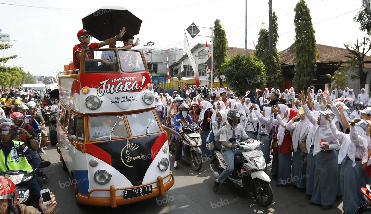 Ribuan siswa sekolah dan warga Kudus menyambut peraih emas bulutangkis Olimpiade Rio 2016, Tontowi Ahmad dan Liliyana Natsir, saat kirab melewati jalan-jalan utama kota Kudus, Kamis (1/9/2016). (Bola.com/Arief Bagus)