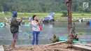 Warga berselfie dengan latar belakang kawasan terdampak bencana tsunami di Carita, Banten, Selasa (25/12). Libur Natal dimanfaatkan warga luar Anyer dan carita untuk menyaksikan langsung terdampak bencana sambil berselfie. (Merdeka.com/Arie Basuki)