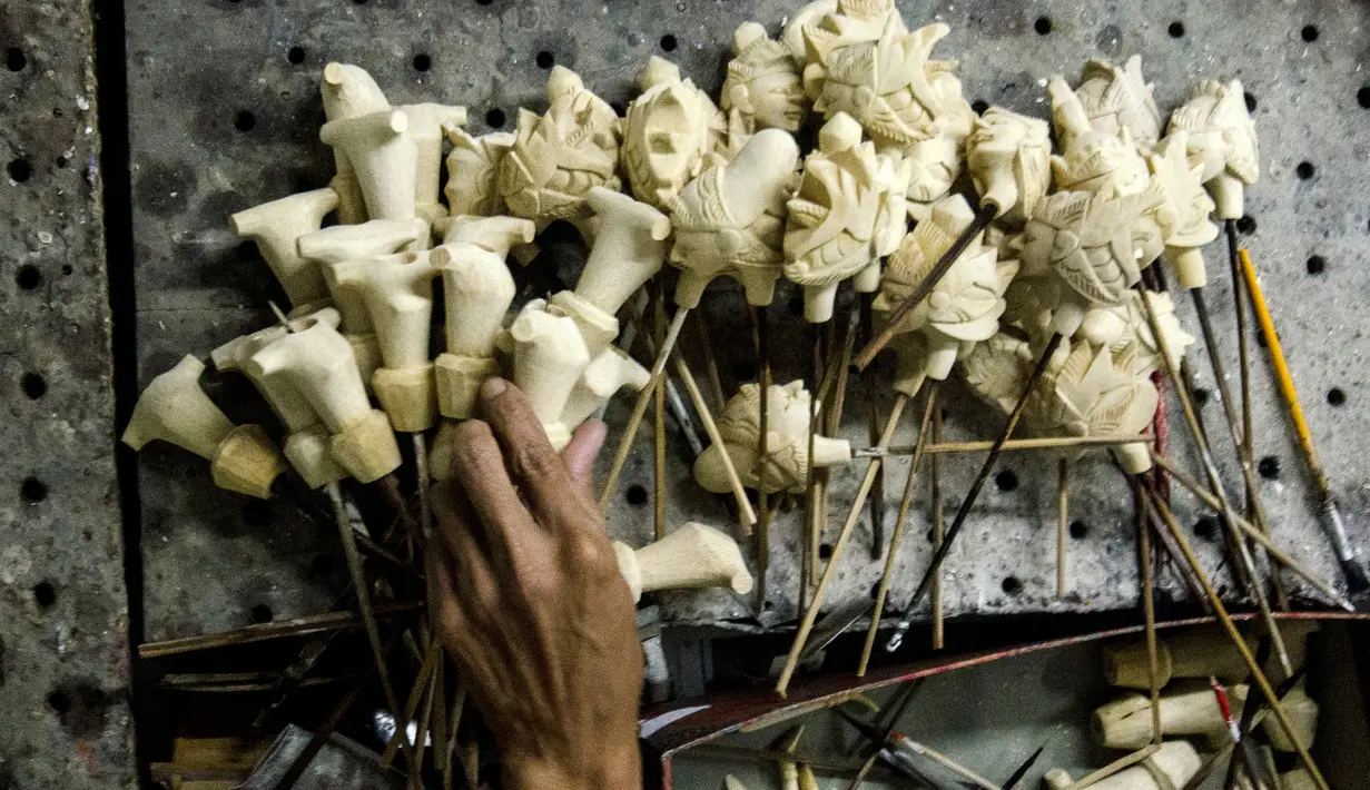 Perajin mengumpulkan bagian-bagian wayang kayu khas Sunda atau wayang golek di galeri kerajinan tangan Cupumanik di Bandung, 17 Februari 2020. Galeri kerajinan tangan Cupumanik memproduksi berbagai wayang golek untuk dijual sebagai cendera mata bagi wisatawan lokal maupun asing. (Xinhua/Septianjar)