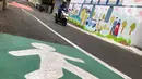 Pengendara sepeda motor melintas di depan mural dan akses khusus pejalan kaki di Jalan Darul Maarif, Jakarta Selatan, Rabu (11/3/2020). PT MRT Jakarta berkolaborasi dengan ITDP menata jalan-jalan sekitar stasiun untuk meningkatkan aksesibilitas warga sekitar. (Liputan6.com/Immanuel Antonius)