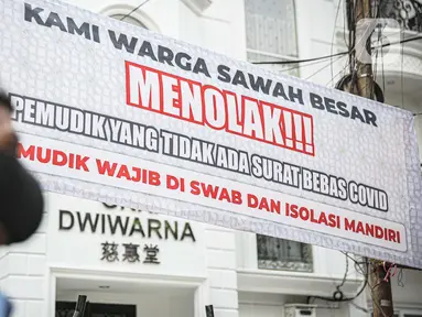 Seorang pria melintas di dekat spanduk peringatan untuk pemudik di kawasan Kartini, Sawah Besar, Jakarta, Senin (17/5/2021). Spanduk tersebut untuk memperingati warga yang kembali dari mudik lebaran agar membawa surat bebas COVID-19. (Liputan6.com/Faizal Fanani)