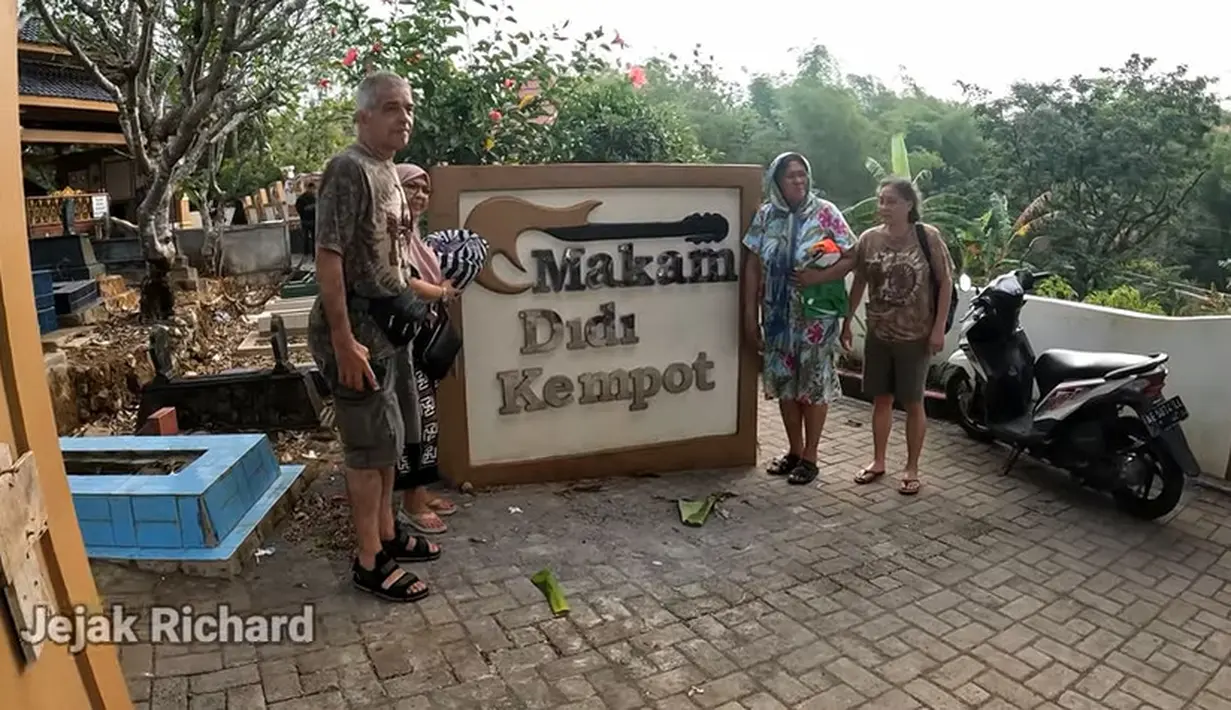 Saat masuk pemakaman, terdapat tulisan dan gambar gitar bertuliskan Makam Didi Kempot. Penggemar Didi Kempot dari Belanda tampak berfoto di dekat tulisan besar. [Youtube/Jejak Richard]
