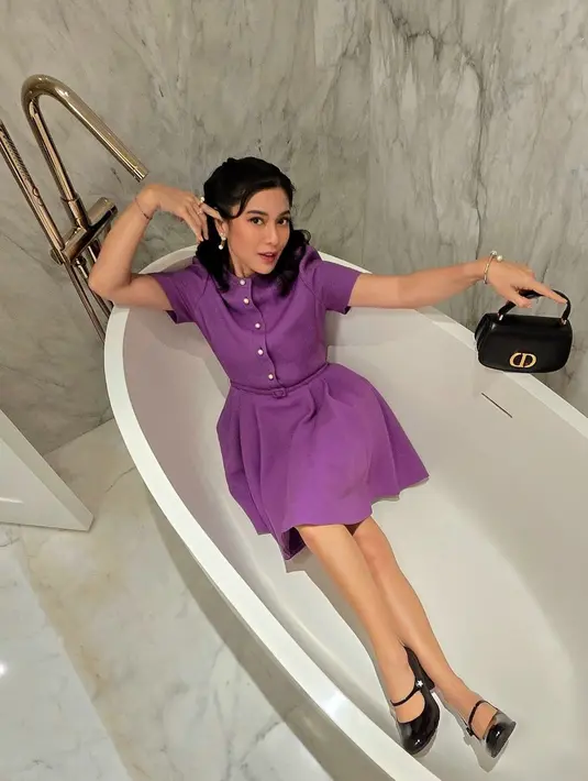 Dian Sastrowardoyo tampil lebih ekspresif dengan mini dress ungu dan pantofel heels hitam [@therealdisastr]