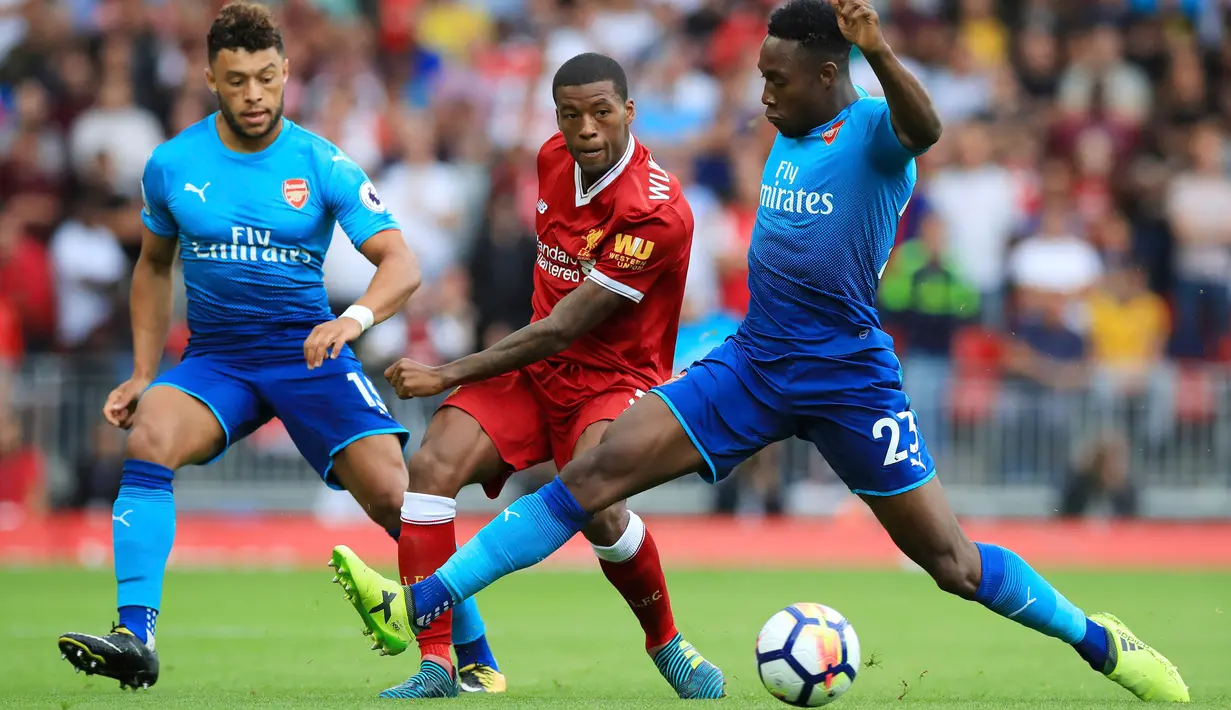 Gelandang Liverpool, Georginio Wijnaldum berusaha melewati dua pemain Arsenal, Alex Oxlade-Chamberlain dan Danny Welbeck pada Liga Inggris di Anfield, Liverpool, Inggris (27/8). Liverpool menang atas Arsenal dengan skor 4-0. (Peter Byrne/PA via AP)