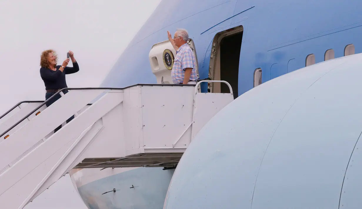 Pengunjung berpose di pintu masuk replika pesawat kepresidenan AS ketika pameran Air Force One Experience di North Kingstown, 18 September 2017. Pesawat replika itu digunakan untuk pusat pembelajaran sekolah. (AP Photo/Stephan Savoia)