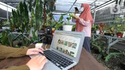 Karyawan mengupload foto tanaman hias untuk dipasarkan secara online di Titik Hijau, Bojongsari, Depok, Jawa Barat, Senin (26/10/2020). Pada masa pandemi COVID-19, penjualan tanaman hias secara online meningkat hingga 100 persen dibandingkan offline. (merdeka.com/Arie Basuki)