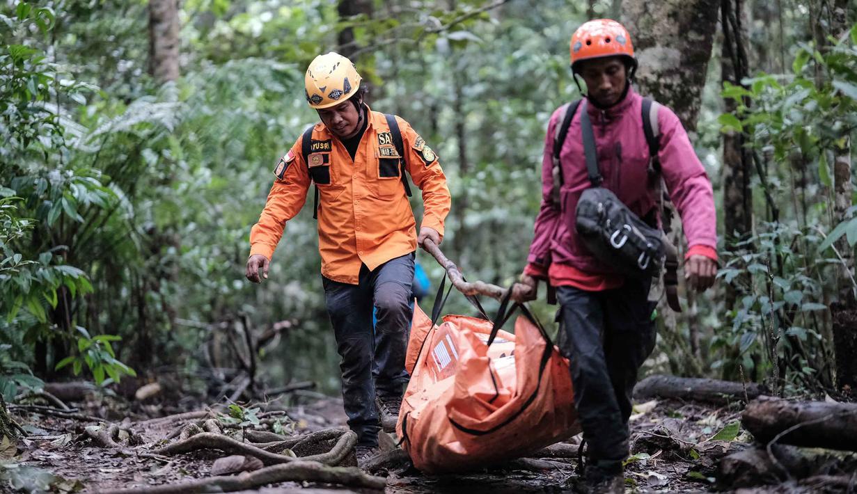 Hingga Minggu 18 Januari 2026, tim gabungan sudah berhasil menemukan puing-puing pesawat serta mengevakuasi satu jenazah dari lokasi kecelakaan di sekitar puncak Gunung Bulusaraung, Sulawesi Selatan. Tampak dalam foto, personel pencarian dan penyelamatan membawa kantong jenazah dari lokasi kecelakaan pesawat turboprop Indonesia Air Transport berjenis ATR 42-500 di Gunung Bulusaraung, Sulawesi Selatan pada Minggu 18 Januari 2026. (Muchtamir Zaide/AFP)