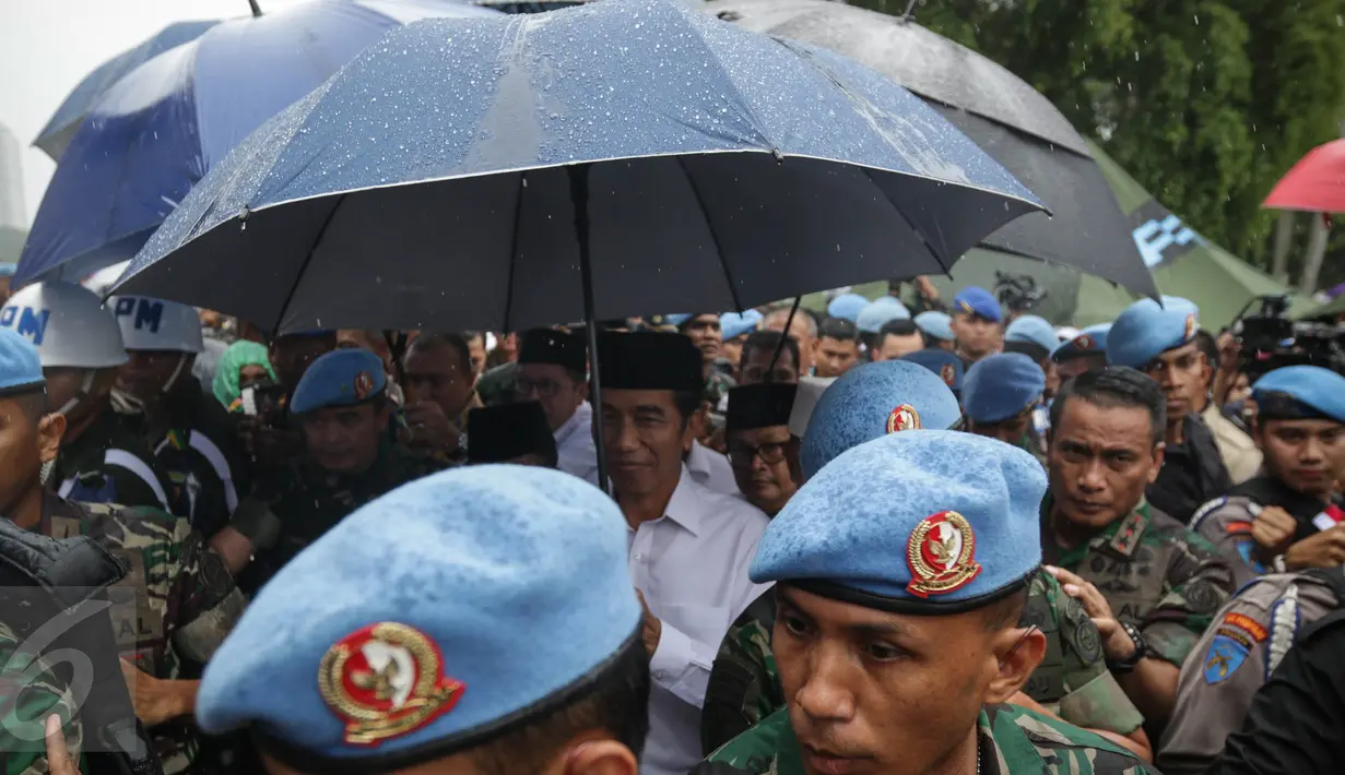 Presiden Joko Widodo berjalan untuk melaksanakan salat jumat bersama dalam Aksi Bela Islam Jilid 3 di Monumen Nasional, Jakarta, Jumat (2/12). (Liputan6.com/Faizal Fanani)
