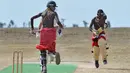Pria dari suku Maasai berlari saat pertandingan amal kriket di kaki Gunung Kenya (18/6). Karena minat penduduk Kenya terhadap olahraga kriket tinggi, akhirnya olahraga ini digunakan untuk kampanye sosial dan lingkungan hidup. (AFP Phoo/Tony Karumba)