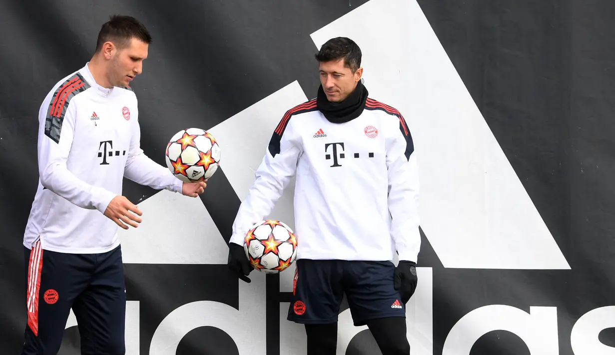 Bek Bayern Munchen Niklas Suele (kiri) dan penyerang Bayern Munchen Robert Lewandowski (kanan) tiba untuk sesi latihan terakhir di Munich, Senin (7/3/2022). Bayern Munchen akan menjalani laga leg kedua melawan RB Salzburg di Allianz Arena pada Rabu (9/3) dini hari WIB. (Christof STACHE / AFP)